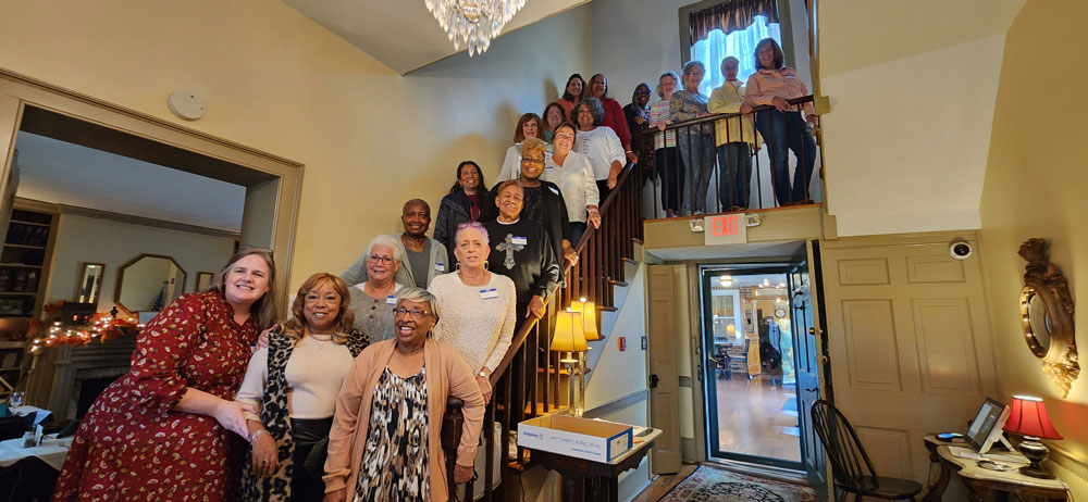 The Team Members All Standing Together On A Staircase